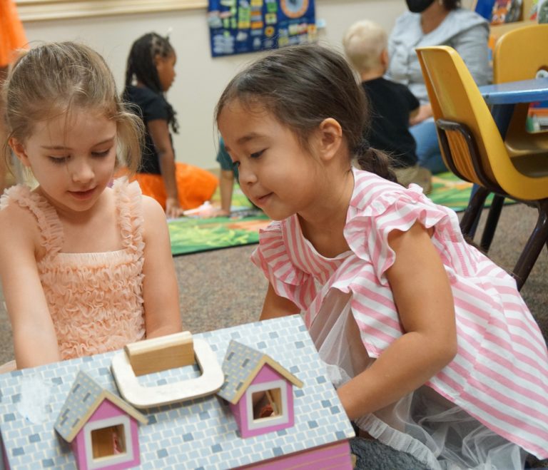 preschool children pretend playing with doll house